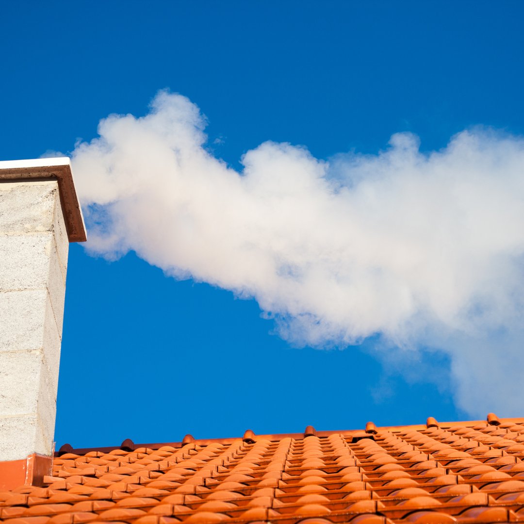 A house chimney with smoke coming out of it